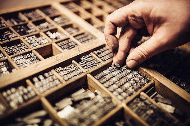 Main manipulant des caractères typographiques pour l'impression traditionnelle